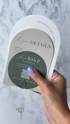 a person's hand holding up a business card with the word details printed on it