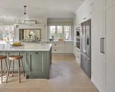 a kitchen with two stools next to an island