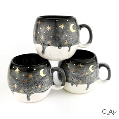 three black and white coffee mugs with stars and moon designs on them, sitting next to each other