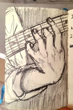 a drawing of someones hand holding an electric guitar strings in their left hand, with words written on it