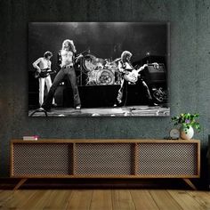 an old photo of the rolling stones in black and white on a wall above a tv