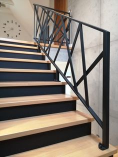 there is a set of stairs with black railings and wood treading on the bottom