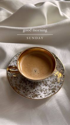 a cup of coffee sitting on top of a saucer with the words good morning sunday