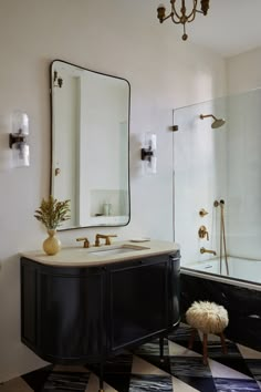 a bathroom with black and white checkered flooring, gold fixtures and a large mirror on the wall