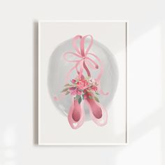 a white plate with pink ballet shoes and flowers on it next to a wall hanging