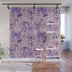 a purple wallpaper with bows on it in an empty room next to a ladder