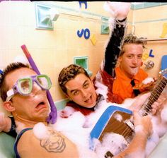 three men are in the bathtub with their guitars and hairdryers around them