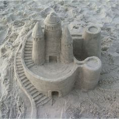 a sand castle built on the beach with stairs