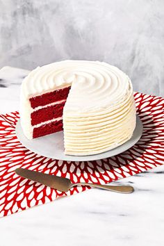 a red velvet layer cake with white frosting