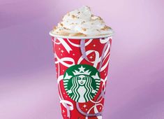 a red starbucks cup with whipped cream on top and bows around the rim, sitting on a purple background