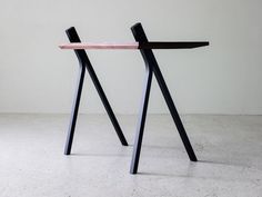 two black and pink wooden objects sitting on top of a white floor next to each other