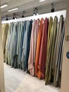 there are many different colors of clothing hanging on the wall