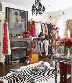 a zebra rug is in front of a closet full of clothes and accessories, with a chandelier hanging from the ceiling