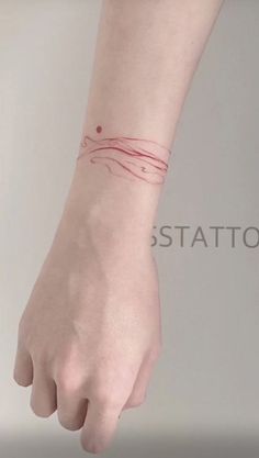 a woman's hand with a red tattoo on her wrist and the word station