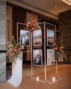 three white vases with flowers and pictures on them in front of a large wall