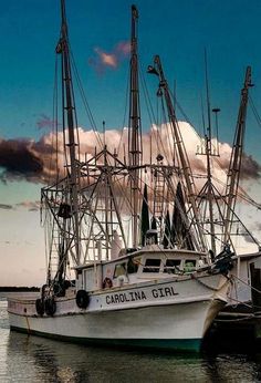 the fishing boat is docked at the dock in the water with other boats around it