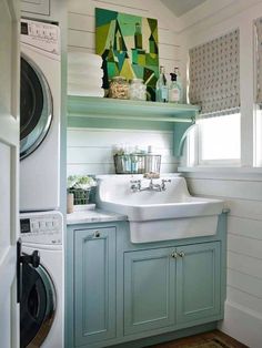 a washer and dryer in a small room with white paneling on the walls