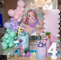 a table topped with lots of balloons and cake next to a sign that says mermaid