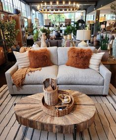 a living room filled with lots of furniture and pillows on top of a wooden table