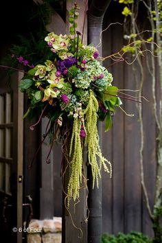 an arrangement of flowers hanging from a pole