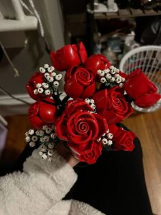 a woman holding a bouquet of red roses