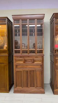 three wooden china cabinets sitting next to each other