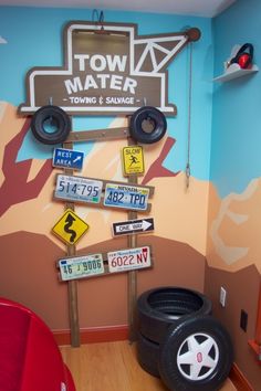 this is a kid's room with cars and signs on the wall, including tires