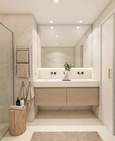 a bathroom with two sinks and a large mirror above the sink is lit by recessed lights