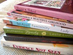 a stack of books sitting on top of a bed