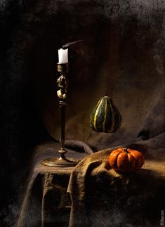 a candle and some pumpkins on a table