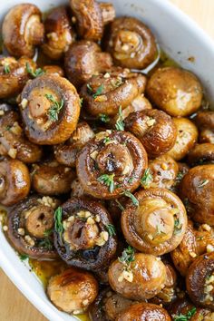 a bowl filled with mushrooms and garnished with herbs