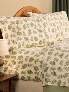 a bed with pine cones on it and a night stand