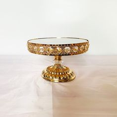 an ornately decorated glass cake plate on a table