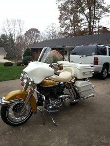 a yellow and white motorcycle parked in front of a house next to a van on the street