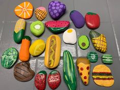 many different types of painted rocks are arranged on the floor with each one's own hot dog