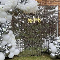 silver and white balloons are on display in front of a photo frame with the words let's do it