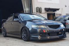 a gray car parked in front of a building