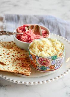 there is a bowl of rice and some crackers on the plate next to it