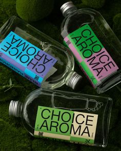 three empty glass bottles sitting on top of green moss covered ground with the words choice aroma written on them