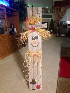 a wooden scarecrow with fall decorations on it