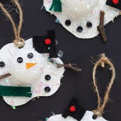 three snowmen made out of paper plates and twine with string attached to them