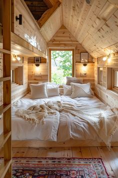 a bed sitting inside of a bedroom on top of a wooden floor next to a window