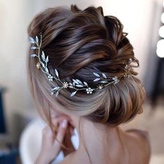 a woman wearing a hair comb with leaves on it's head and braids in her hair