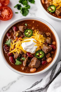 two bowls of chili soup with sour cream on top