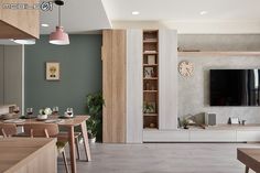 a living room filled with furniture and a flat screen tv mounted on a wall above a fireplace