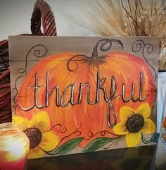 a wooden sign that says, happy thanksgiving with sunflowers and a pumpkin on it