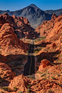 an empty road in the middle of some mountains