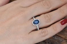 a woman's hand with a ring on it and a blue stone in the middle