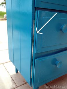 a blue dresser with white marks on the top and bottom drawer, showing where it is located