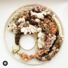 a white plate topped with lots of different types of yarns and flowers on top of it